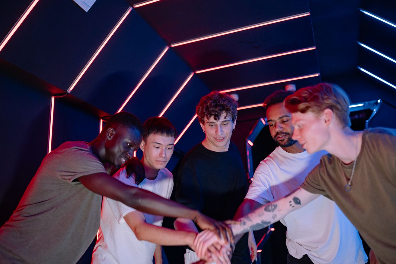 A diverse group of young friends unite in a neon-lit futuristic room, symbolizing teamwork.